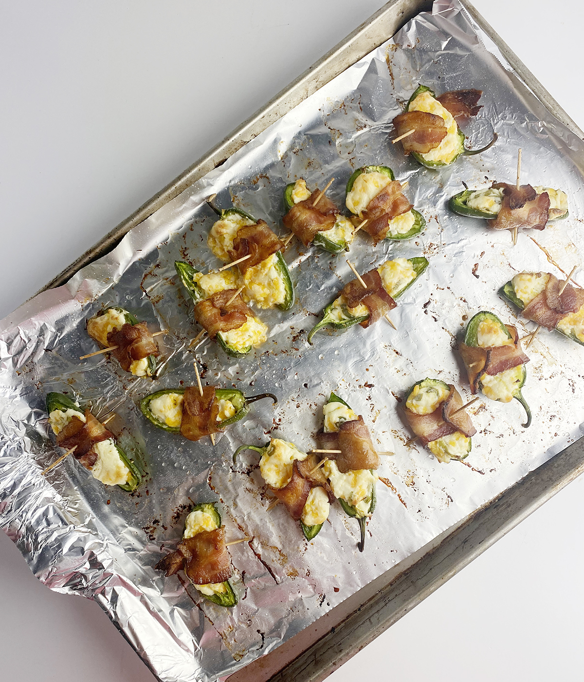 Baked jalapeno poppers on a baking sheet.