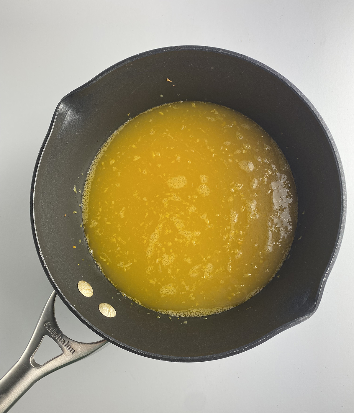 Chicken broth with chopped vegetables in a pot.