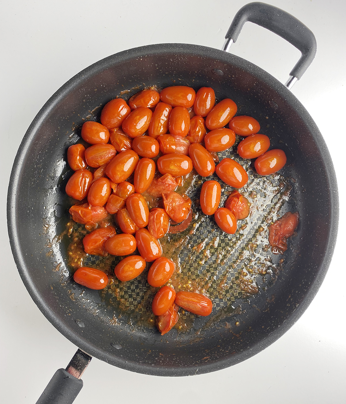 Cherry tomatoes sauteed in a pan.