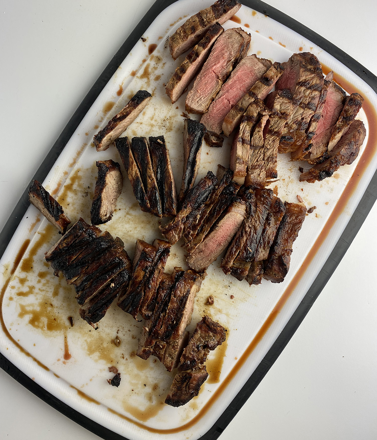 Grilled and sliced steak on a cutting board.