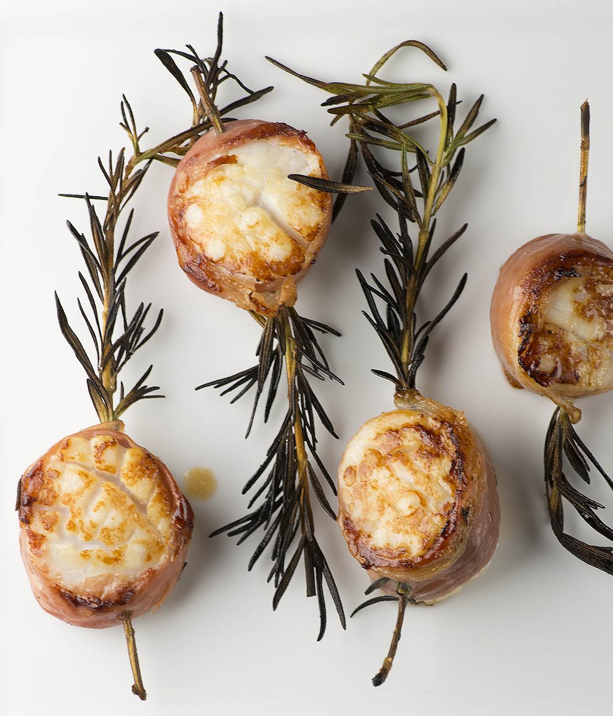 Grilled rosemary scallops on a plate.