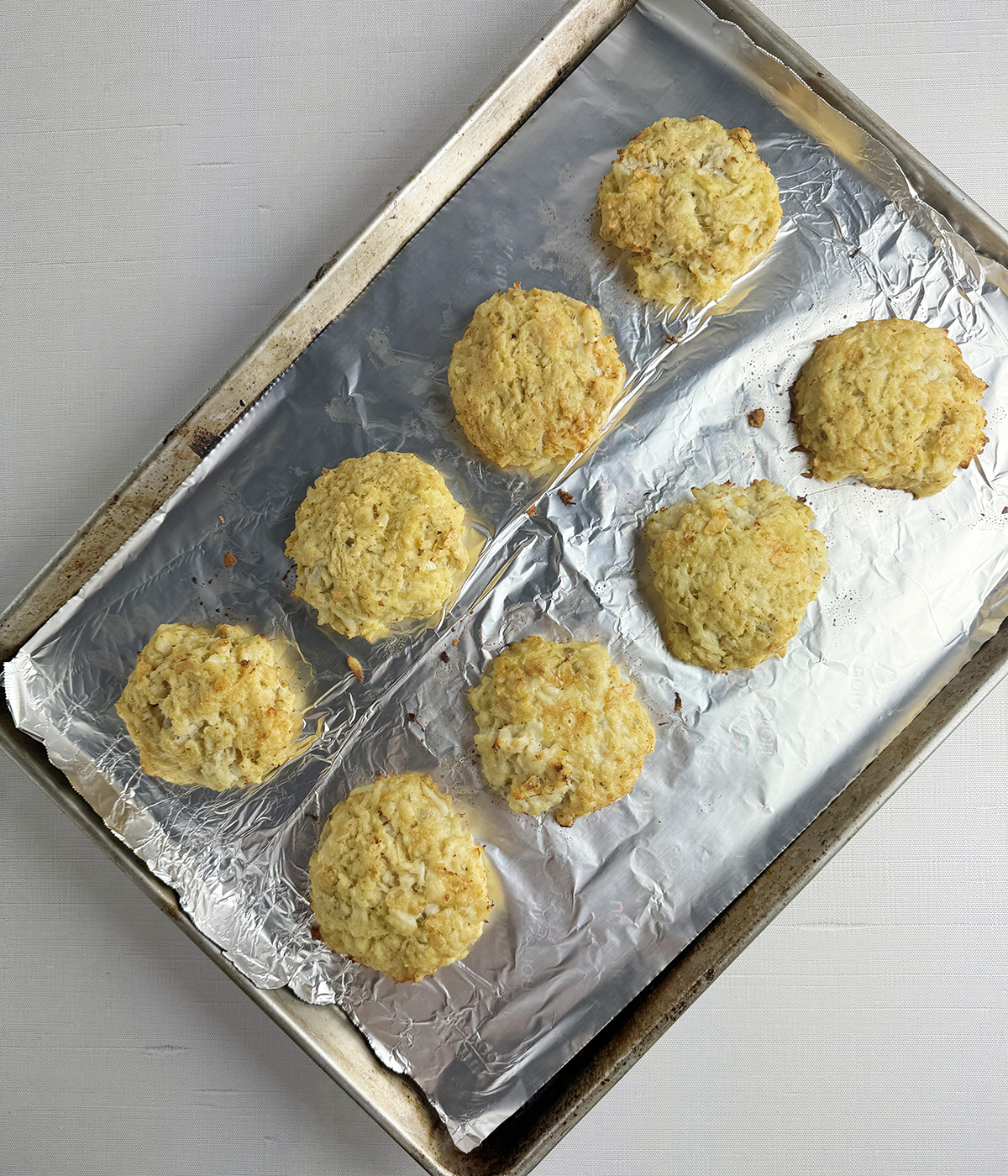 Baked crab cakes on a baking pan.