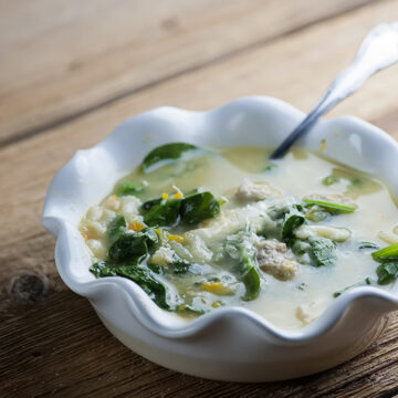 Italian wedding soup in a bowl with a spoon.