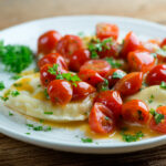 Ravioli with white wine tomato sauce on a plate.