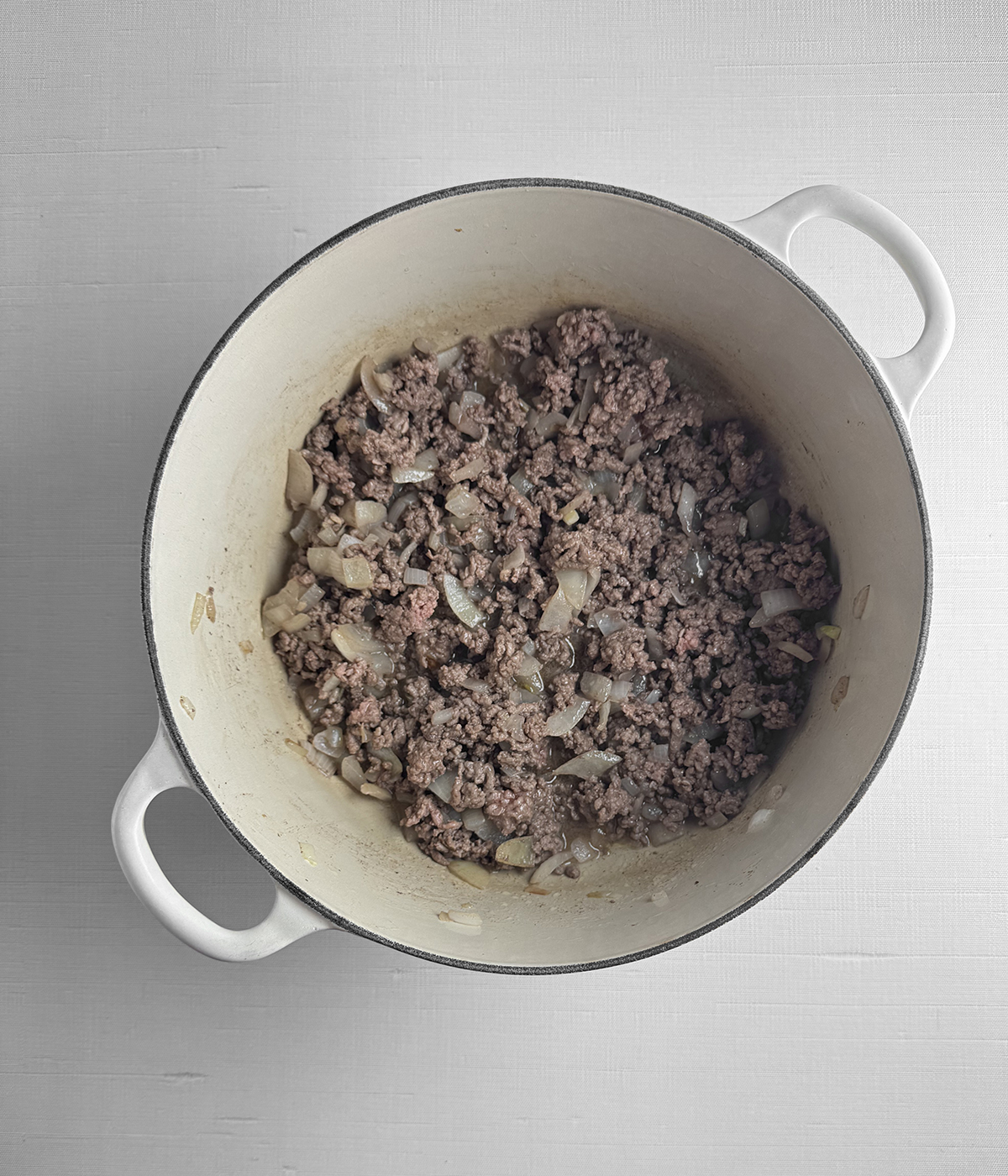 Ground beef and onions in a pot.