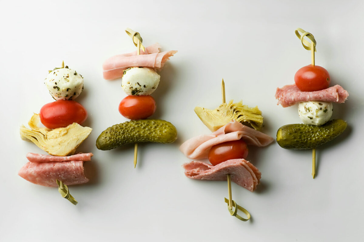 Antipasto skewers on a white platter.