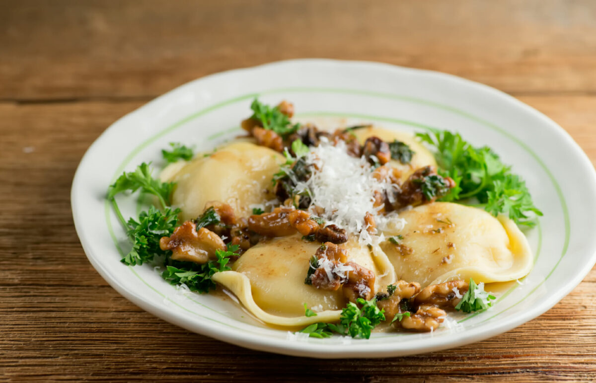 Cheese ravioli with toasted walnut sauce on a plate.