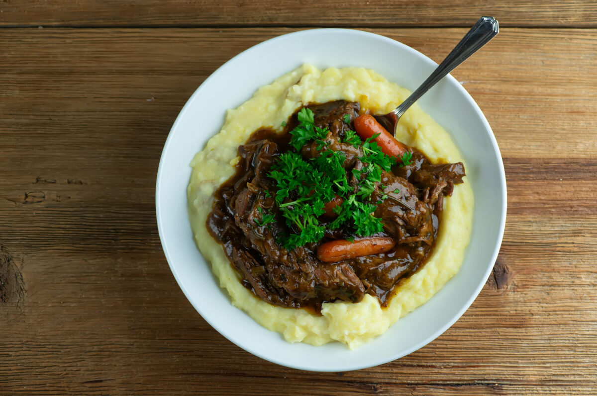 Maple Pot Roast in a bowl with polenta.