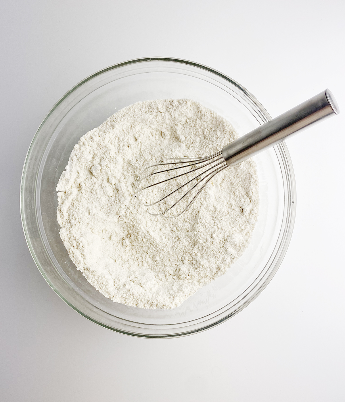 Flour mixture in a mixing bowl with a whisk.