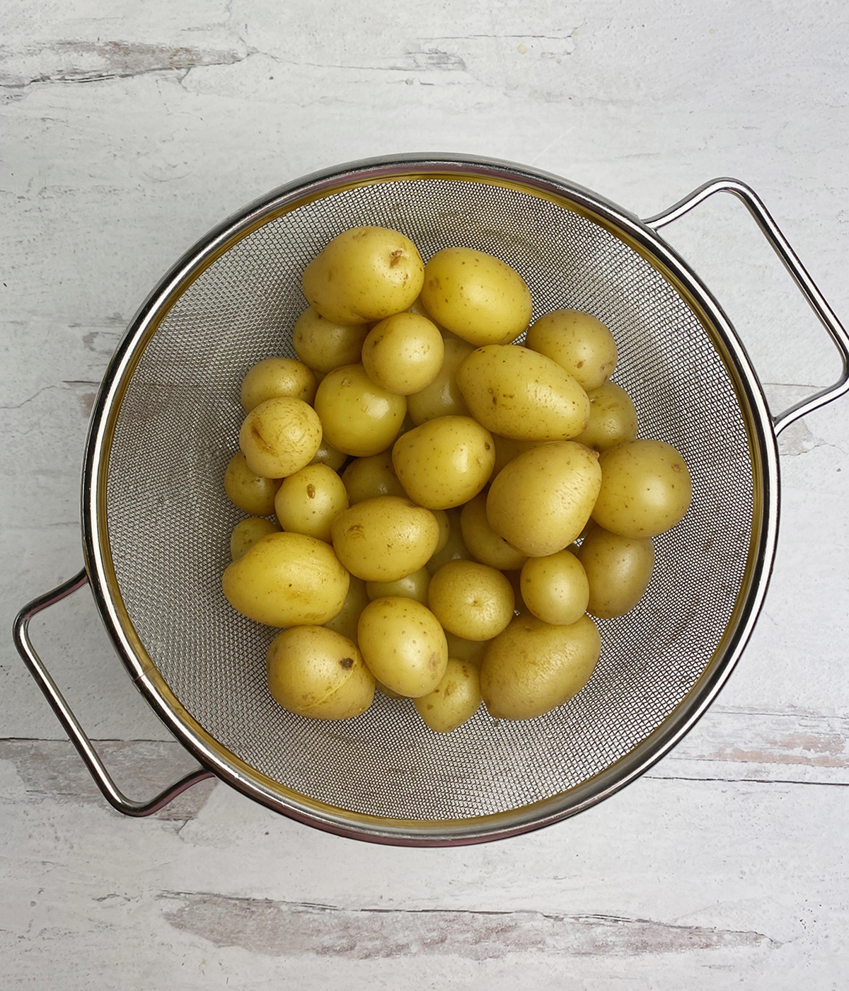 Baby potatoes draining in strainer.