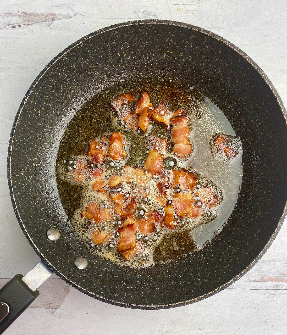 Bacon cooking in a skillet.