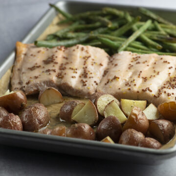 Roasted salmon and vegetables on a baking pan.